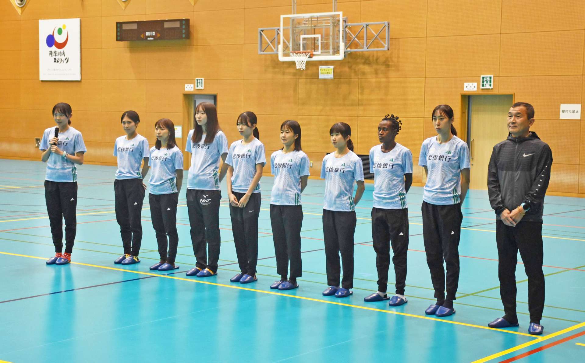あいさつする久保心優選手（左端）ら肥後銀行女子駅伝部の選手と監督＝薩摩川内市のサンアリーナせんだい