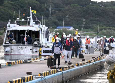 〈関連〉下船する作業員とみられる人々＝８日午前８時ごろ、西之表市の住吉漁港