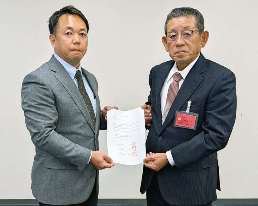 九州防衛局の担当者（左）に要望書を手渡す中津川区公民館の寺脇伸治館長＝１１日、福岡市（さつま町提供）