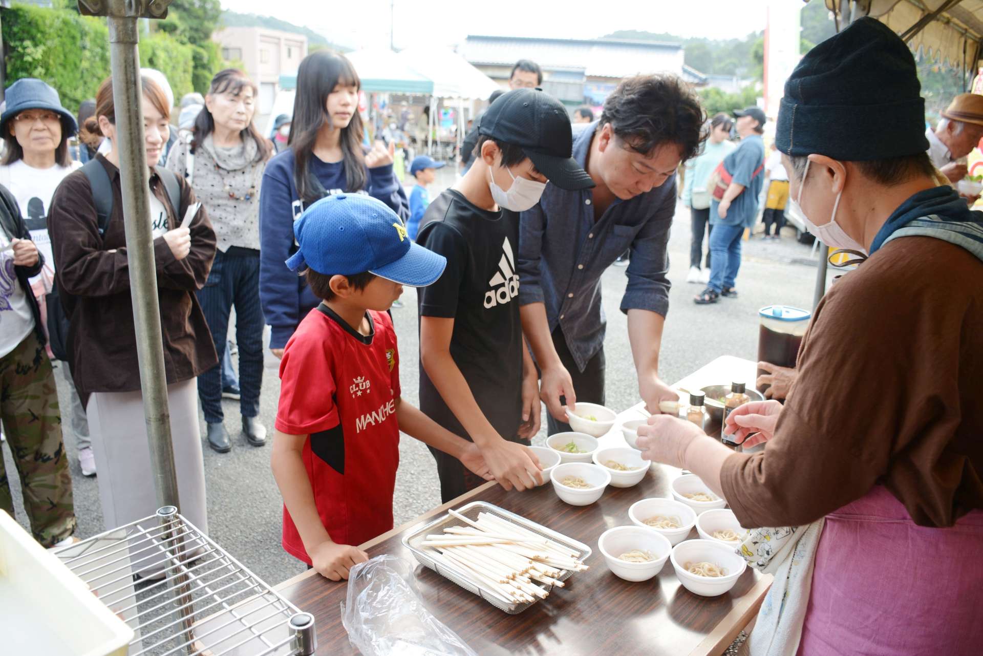 振る舞いそばを受け取る来場者＝鹿児島県枕崎市田布川町