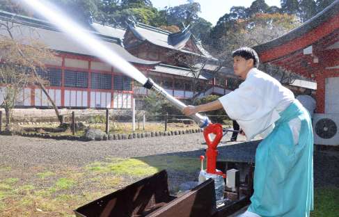 新設した放水銃を操作する神職＝霧島市霧島田口の霧島神宮