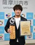 海外地域振興大賞のトロフィーを手にする山下賢太代表＝薩摩川内市役所