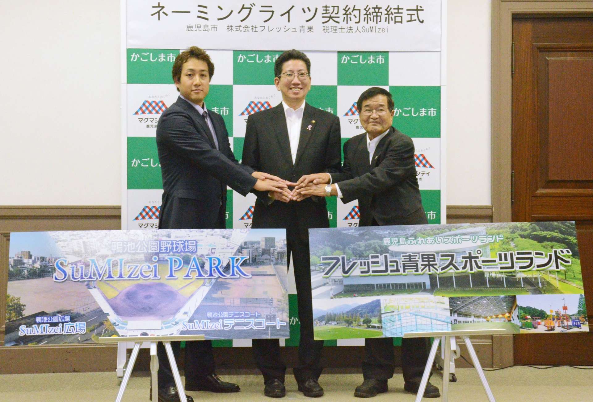 鹿児島市と命名権契約を結んだＳｕＭＩｚｅｉの角囿友章代表（左）とフレッシュ青果の西原正信会長（右）＝１４日、市役所