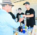 イベント来場者に焼酎カクテルを振る舞う熊本大球磨焼酎愛好サークルの古澤龍さん（右）ら＝１０月１２日、人吉市