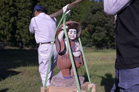 下狩宿集落の住民に担がれ田んぼを回る田の神＝１４日、さつま町求名