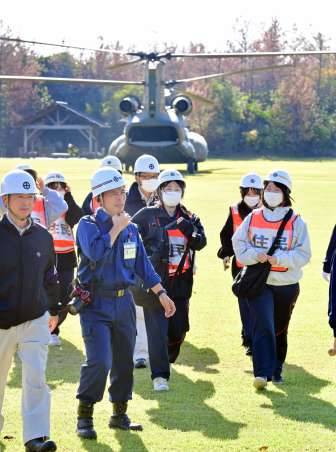 大型ヘリから降り誘導員とともに移動する住民役＝１５日午前１０時すぎ、鹿児島市桜島横山町