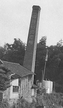昭和51年、旧伊集院町、窪田酒造の赤レンガ造りの傾く煙突。高さ約25メートルで「日置郡で最も高い煙突として君臨」してきたが、「8年ほど前から傾き始めた」。その後台風で倒壊、名物煙突は姿を消した。