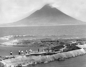 昭和43年、旧頴娃町の番所鼻公園からのぞむ開聞岳。「番所鼻、戸柱の両公園からのぞむ開聞岳の姿は美しく“薩摩富士”と呼ぶにふさわしい。海岸線からは、空気の澄んだ日など屋久連山、硫黄島、黒島などを見ることができる」