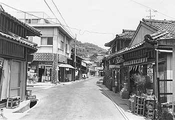 昭和49年、旧坊津町坊地区。「坊津町は海岸に沿って東西に長い町。そこに坊、泊、久志、今岳、秋目と集落が点在し、端から端までは車で小一時間かかるという地形で、購買力が分散するし、中心となる商店街も形成されにくい」と当時の紙面。