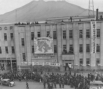 最終日の南日本新聞社前、1位でゴールする川薩・中ノ上選手をテープと紙吹雪が出迎える＝昭和36年1月14日
