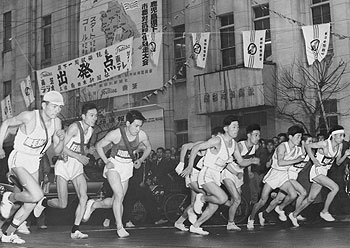 雨の中、南日本新聞社前を一団となってスタートする選手＝昭和37年2月24日