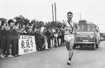 第1日7区、頴娃高校前で同校教官の東選手（指宿）に声援を送る生徒たち＝昭和38年2月23日