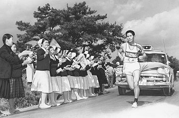 第1日5区、看護婦の声援を受けて地元を走る菊永選手（川辺）＝昭和38年2月23日