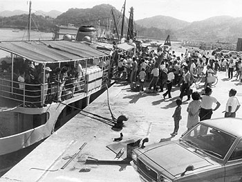 昭和47年8月、川内内港岸壁。当時の紙面では、「航路新設の認可遅れで延び延びになっていた甑島航路定期船の川内寄港がやっと実現、第一船の九州商船所属、野百合丸が川内港に初寄港、満員の乗客を乗せて甑島に向かった」と伝えている。