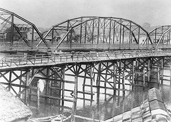 明治33年ごろ、川内川に架かる初代太平橋（手前）と架設されたばかりのロンドン・ブリッジ（奥）。初代太平橋は明治8年に完成し、明治33年に廃橋、かわって英国から輸入したロンドン・ブリッジがお目見えした、と昭和38年の紙面で振り返っている。
