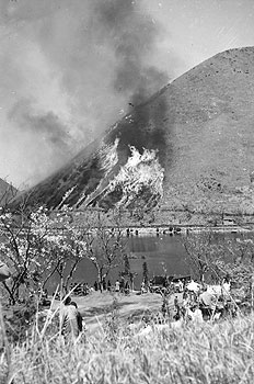 昭和38年4月、旧祁答院町藺牟田湖観桜会で行われた野焼き。「標高四百九十五メートルの飯盛山の火入れは午後一時半に始められ、ぐれんの炎が約四十分間で五十ヘクタールのカヤを焼きつくす壮観さはみんなの拍手を浴びた」と伝えている。