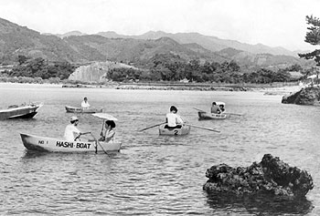 昭和42年、阿久根市の大川島海岸。「今夏から大川島海水浴場が開かれる。貸しボートも浮かべ、砂がきれいなのと、危険性がないので、子どもや家族連れに最適」と当時の紙面で紹介している。
