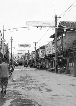 昭和33年、出水市の仲町商店街。当時の紙面によると、地方商店街がさびれる中、県が同商店街を対象に診断を実施。「診断後、二割の売上げ増をあげたが、各商店がきわめて意欲的だったことが最大の要因とされる」と報じている。