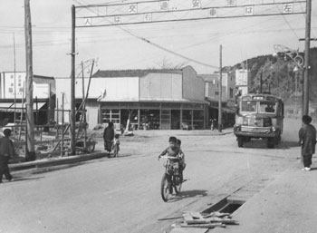 昭和３２年４月、旧垂水町のアーチ型交通安全標識。紙面は「同町ではことしに入ってすでに６件の交通事故が発生。このほど３地区にアーチ型安全標識をたて、事故防止への協力を求めている」と伝えている。