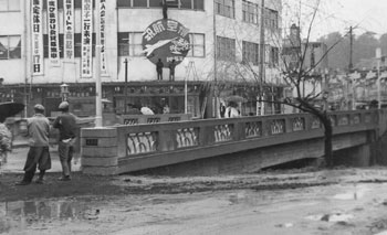 昭和３３年３月、鹿屋市の鹿屋橋。紙面によると「橋は車道６メートル５０、両側に２メートルずつの歩道をもつ鉄筋コンクリート製。同月十五日に完工祝賀式が開かれた」と伝えている。