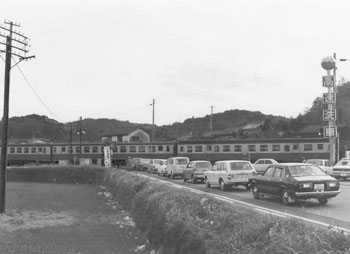 昭和５０年２月、鹿屋市の田崎踏切。「同踏切は朝夕のラッシュ時に数百メートルもの車の行列ができ交通のネック。市が立体交差計画を進め、ことし夏にも着工する」と紙面は報じている。