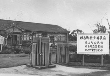 昭和４６年２月、旧根占町の南大隅高校跡。紙面は「ここは明治時代の偉人・中村博愛の誕生地。いまは古校舎を利用して町商工会、公民館、図書館が同居している」と報じている。