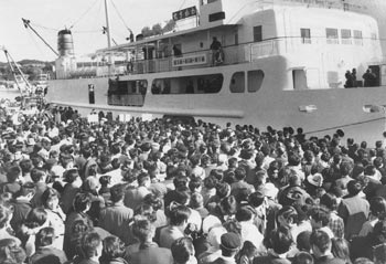 昭和４６年１月、正月を種子島で過ごした帰省客が本土に帰るため、大混雑した西之表港。紙面によると「前日に台風並みの大シケで定期船が欠航。例年にも増して超満員となった」などと紹介している。