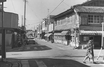 昭和４９年７月、大型ホテル建設にゆれる上中地区の商店街。“ロケットの町”で観光振興をはかるが、紙面では「既存業者の懸念の声もある。一方で、種子島－屋久－山川の三角航路の活用促進や道幅の狭い上中地区のバイパス建設など課題も多い」などと報じている。