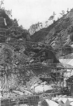 昭和３６年１２月、開発進む屋久島のダム掘削工事の様子。当時の紙面では「安房川第一発電所第二期工事が工費１２億円で６月に始まり、本格的なダム建設に入った。新ダムは高さ５３メートル、幅１４０メートルもあり、完工後は合計２万３０００kwの出力となる」と伝えている。