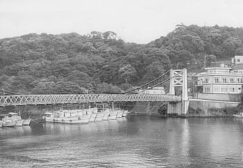 昭和５０年６月２７日、保存求める声が出ている安房つり橋。当時の紙面では「安房川にかかるつり橋は両端の橋脚からワイヤーでつるし、本体は木材を使ってある。これが白アリ被害にあって、余命１年ばかりと町では見ている。地元では『バイパス橋ができ交通の主役は譲っているが、生活道としても利用され、また船の係留も含めて安房の景観に欠かせない』といった声があがり、保存運動が起こっている」と報じている。