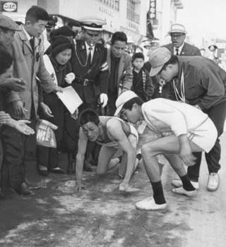 第4日、岩川中継点30メートル前で倒れ、はいながら中継点に向かう山口選手（大口）＝昭和40年2月21日