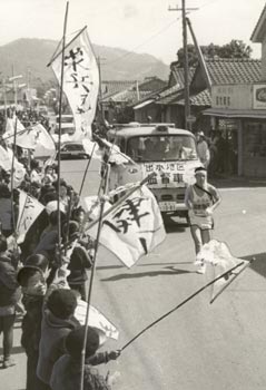 第1日、手づくりのノボリを立て沿道から応援＝昭和41年2月18日、開聞小学校前