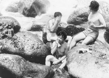 昭和４５年８月、横当島の“ヨコアテ”温泉。当時の紙面は「北側入り江にあり、地熱で海水が温まった“即席ブロ”。満潮時は海の底に沈んでしまい、干潮には干上がる。その中間でないと利用できない」と伝えている。