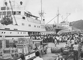昭和３９年８月２６日、相次ぐ台風の影響で海上交通がストップしていた名瀬港に定期船３隻が相次ぎ入港。紙面は「２５日朝から八坂丸、高千穂丸、興南丸がいずれも野菜や食料品、お客を満載して接岸。約１０００人の客と貨物で桟橋はあふれた。高千穂丸と興南丸は新たに２６０人の乗船客をのせて南の離島へと、また八坂丸は足止めをくっていた帰省客など４００人余りをのせて、鹿児島に折り返し出港した」と報じていた。