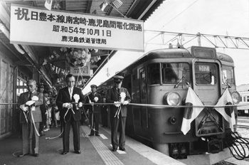 昭和５４年１０月、日豊本線・鹿児島－南宮崎間の電化工事完工で九州を環循する電化路線の開通を祝う発車式・開通式。当時の紙面は「電化第１便の急行『錦江１号』が西鹿児島駅のホームに入ると前面に日の丸が飾られ、紅白のテープが渡された。狭いホームは制服姿の国鉄幹部や関係者、ファンなどでぎっしり。線路ぎわには鉄道マニアたちがカメラの放列を構え、車内からマイクを据え発車式のもようを録音する若者も」と報じている