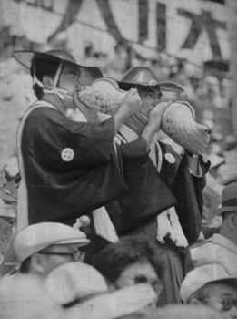 昭和４９年８月、妙円寺参りの陣羽織姿でホラ貝を吹く応援団。当時の紙面は「鹿児島実のベスト８進出がかかった大会第７日、お盆休みの激闘に甲子園は朝から興奮気味。午前１０字の試合開始前から一塁側アルプススタンドは超満員で、スタンドに入れぬ人たちは外野席の最上段で立ち見を始めた」と伝えている。