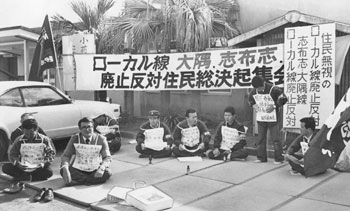 昭和５５年１１月、ローカル線廃止反対を訴えて志布志町（現志布志市）の志布志駅前で座り込む国労、動労の組合員。当時の紙面は「ローカル線廃止対象の大隅、志布志両線と日南線につながる同町では午前１０時から駅前に畳を敷き座り込み。志布志線を守る会の代表らが乗降客にスピーカーでアピールした」と報じている。