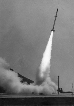 昭和４０年８月、球型ロケットを搭載し、衛星開発予備実験として内之浦町（現肝付町）から打ち上げるカッパ１０Ｓ型１号機。「球型ロケットは直径３０センチ、重さ２０キロで内部には燃料がぎっしり。将来の人工衛星開発に直接重要なデータを与える」と紙面は伝えている。