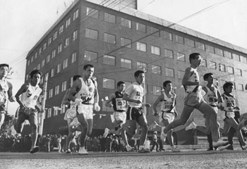 昭和４７年２月１２日、第１９回県下一周駅伝が開幕。５月に本土復帰する沖縄をはじめ１２チームが健脚を競った。写真は鹿児島市易居町の旧南日本新聞社社屋前。