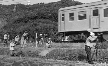 昭和６２年、消えゆく地域の足を記録にとどめておきたい－写真愛好家で作っている国分写友会は、国鉄（現ＪＲ）をテーマにした写真展を開いた。写真は大隅線を撮影する国分写友会。紙面では「写真展では住民の暮らしを支えてきた同線への感謝と惜別の念を込めた写真をそろえた」と報じている