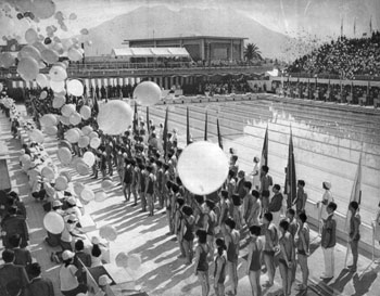 昭和４７年９月１７日、鴨池水泳プールで行われた第２７回国民体育大会夏季大会開会式。紙面では「高らかなファンファーレと勇壮なマーチとともに各県えりすぐりの選手団が入場。金丸鹿児島県知事が開会宣言。鹿児島県福重選手が『力いっぱい戦います』と選手宣誓した」と報じている。