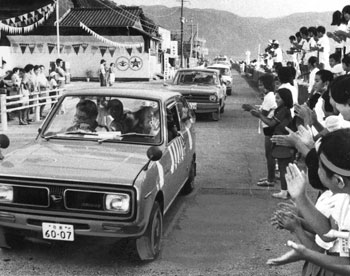 昭和４７年、太陽国体夏季大会で日本一になった福山高クルーを歓迎する町民。紙面では「福山高クルーの国体優勝で錦江湾奥の牛根－境－福山－国分の町々は喜びにわいた。選手や応援団一行の車が町に入ると、沿道は歓迎のうず、たちまち優勝パレードに早変わりした。パレードは亀割峠を越え国分市（現霧島市）敷根を経て、牧之原まで行い、福山高校でバンザイを叫んでわかれた」と報じている。