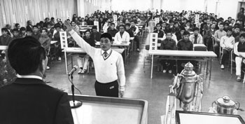 昭和４８年２月９日、第２０回県下一周駅伝開会式。写真は「正々堂々と戦うことを誓います」と力強く選手宣誓する、昨年優勝の日置地区代表松元公男選手。「過去３年連続オープン参加していた沖縄が出場を見合わせ、かわって伊佐地区が２年ぶりに、郷土の声援を受けて出場、各市郡代表の１２チーム全部が出そろった」と紙面で報じている。