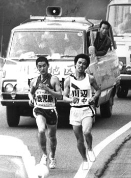 昭和４８年、第２０回県下一周駅伝第２日。加世田市役所前から出水市役所をめざし１０区間１１７．３キロのコースで健脚を競った。写真は６区川内市内での野間口（鹿児島）田中（川辺）の激しいトップ争い。「川辺と鹿児島が最終区まで激しい首位争いを演じ、沿道を湧かせた。鹿児島のヤング勢が奮起一番、川辺を最終区でとらえ引き離した」と報じている。