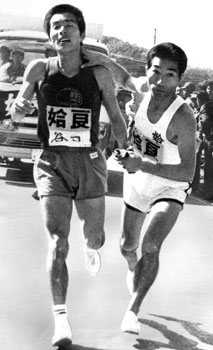 昭和４８年２月１２日、第２０回県下一周駅伝第３日。さつま町求名中継所でオイからオジへのバトンタッチ。谷口選手と田中選手（姶良チーム）。