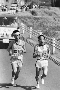 第２０回県下一周駅伝大会第４日。末吉町（曽於市）岩崎中学校付近で曽於・北野選手、川辺・上窪選手を抜いてトップに立つ。紙面では「大会第４日、肝属、曽於が常に上位を走り、沿道は大いにわきかえった。地元を走る曽於と郷土入りの肝属が健闘、上位を突っ走り、肝属は昨年に続いて日間優勝を飾った」と報じている。