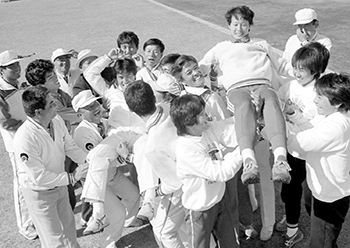 「あかぎ国体」最終日の昭和５８年１０月２０日、前橋敷島公園県営陸上競技場でアベック優勝の中村夕紀子（右）、宮崎博史両選手を胴上げして大喜びの鹿児島県選手、役員団。紙面では「インタビュー攻めに合った宮崎さんと中村さんが前後して、県選手団の控え所に帰ってきたのはレース後１時間もたっていた」と報じている。