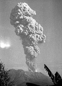 昭和３７年１２月１０日午後３時１１分、３０００メートルまで上がった噴煙。紙面では「桜島南岳はこのところ第１２活動期に入って以来、最強の活動を続けている。１０日は１日５回も地震をともなった爆発を続け、多量の降灰、噴石、噴煙を上げた。京大の桜島火山研究所の地震計は連続微動を記録するほか、終日黒煙を上げ市民の関心を集めた」と報じている。
