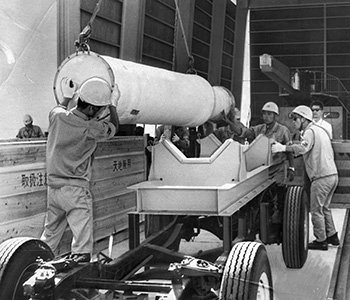 昭和４３年９月７日、種子島宇宙センターに運び込まれたロケット本体。搬入されたロケットは昭和４２年３月発射寸前に打ち上げが中止されたまま持ち帰っていたＬＳＣ－Ｄ機のブースターと小型ロケットＳＢ－II、同III型機、さらにＮＡＬ－１６Ｈ１、２号機。西之表港に陸揚げされた後、時速２０キロののろのろ運搬で種子島縦貫道を進み５時間かけてセンターに着いた。