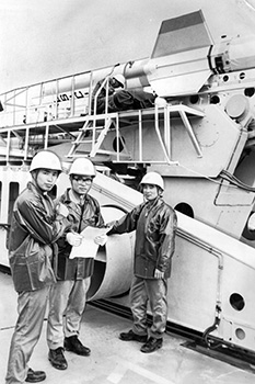 昭和４３年９月１６日、種子島宇宙センターＬＳＣ機リハーサルでの若手グループの３人。左から柴藤、笹谷、斉藤さん。紙面では「科学技術庁のロケット開発陣は若手が多い。大学を出て２、３年、２５、６歳の技術者たちが意欲的にロケットに取り組んでいる。歴史が浅く、むしろこれから本格的にロケット開発にかかる同庁らしき若々しさだ」と報じている。